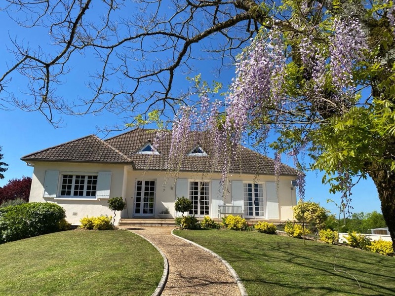 The main house across the lawn with wisteria in flower